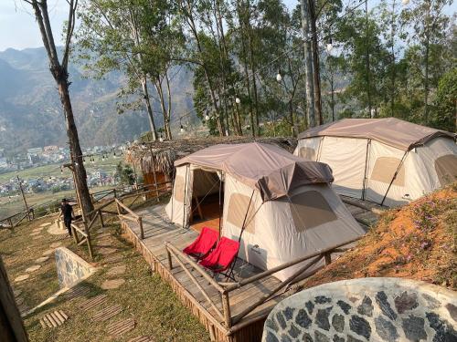 2 Zelte auf einem Hügel mit roten Stühlen in der Unterkunft Best View Đồng Văn in Ha Giang