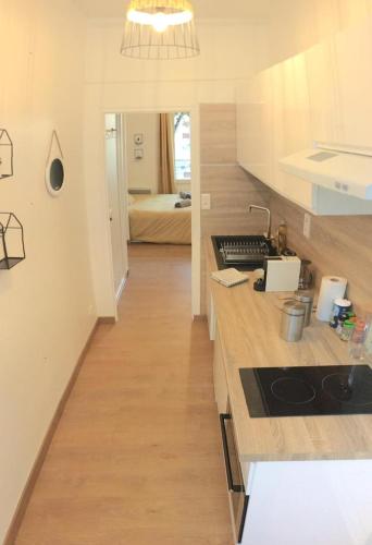 une cuisine avec un comptoir et une chambre avec un lit dans l'établissement Le Skandi - 28 m² rénové entre gare & centre-ville, à Vichy