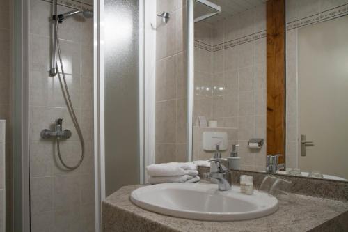 a bathroom with a sink and a shower at Hotel Kieffer in Itterswiller