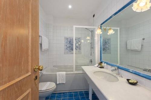 a bathroom with a sink and a toilet and a tub at Grand Hotel Mediterranee in Alassio