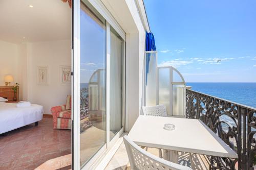 a balcony with a bed and a view of the ocean at Grand Hotel Mediterranee in Alassio