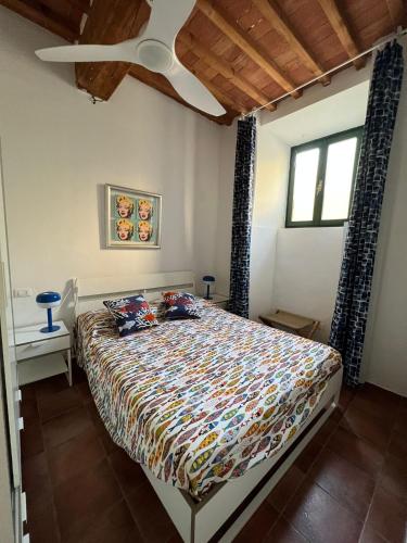 a bedroom with a bed and a ceiling fan at Le petit refuge in Capraia