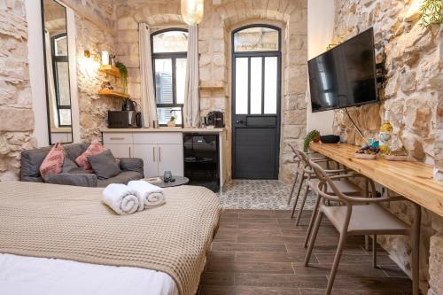 a room with two beds and a kitchen and a table at ארגמן סוויטות בוטיק in Safed