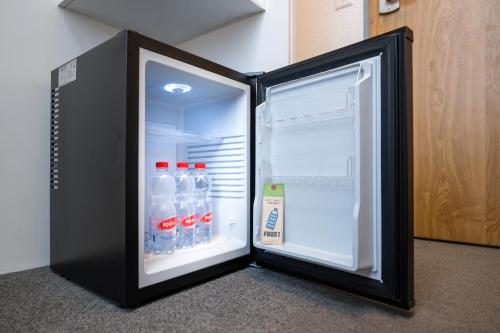 an open refrigerator with bottles of water in it at Hotel Waldhorn in Bern