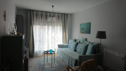 a living room with a blue couch and a window at PONTECESO, MAR Y FER in Ponteceso