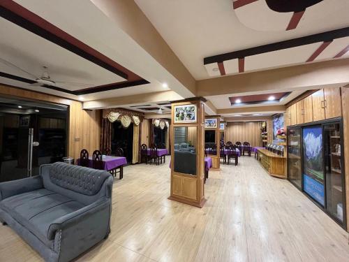 史卡杜的住宿－Blue Sky Hotel & Restaurant，一间配备有沙发、桌子和紫色椅子的客房