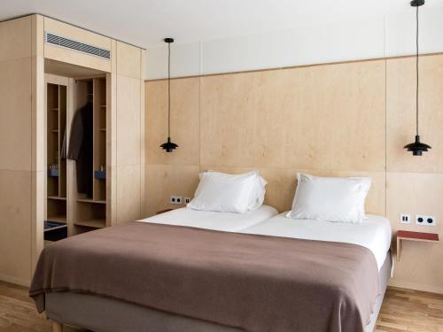 una camera da letto con un grande letto con due cuscini di New Hotel Opéra a Parigi