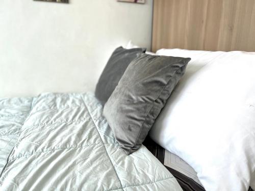 a bed with two gray pillows on top of it at City center + walk in closet in Cebu City