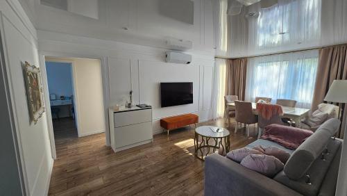 a living room with a couch and a tv at Apartmány Rudlová Glamour in Banská Bystrica