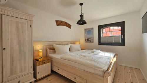 ein Schlafzimmer mit großem Bett und Fenster in der Unterkunft Speicherresidenz N 0,1 in Barth