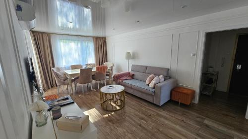 uma sala de estar com um sofá e uma mesa em Apartmány Rudlová Glamour em Banská Bystrica