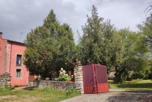 una puerta roja sentada frente a una pared de piedra en La Perseverancia, en Aldehuela