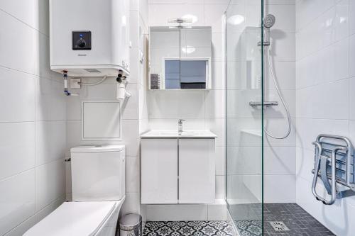une salle de bain blanche avec toilettes et douche dans l'établissement Le Métropolitain - Proche de Paris - 338B, à Nogent-sur-Marne