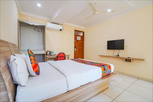 Habitación de hotel con cama y TV en FabHotel BNS Comforts, en Bangalore