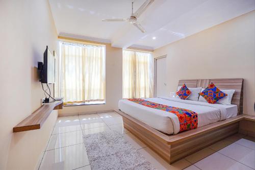 a bedroom with a bed and a flat screen tv at FabHotel BNS Comforts in Bangalore