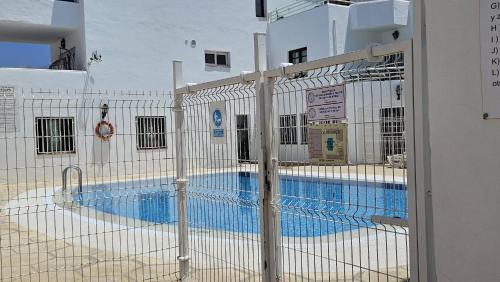 a fence in front of a swimming pool at Oasis del sur, sea view los cristianos in Los Cristianos