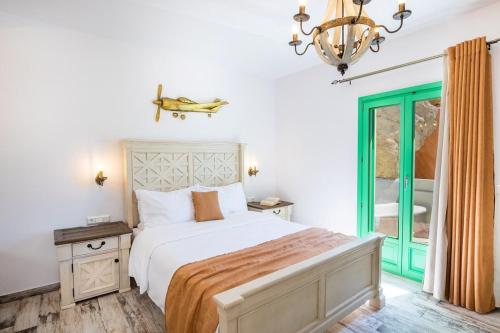 a bedroom with a bed and a chandelier at La Scala Luxury Villa Μikis Theodorakis with jacuzzi in Karpathos Town