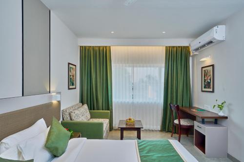 Habitación de hotel con cama y escritorio en Abad Fort, en Kochi