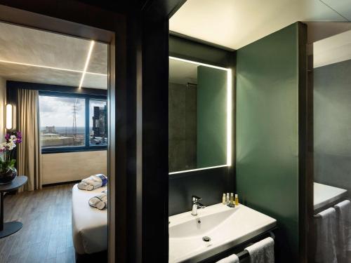 bagno con lavandino e specchio di Novotel Genova City a Genova