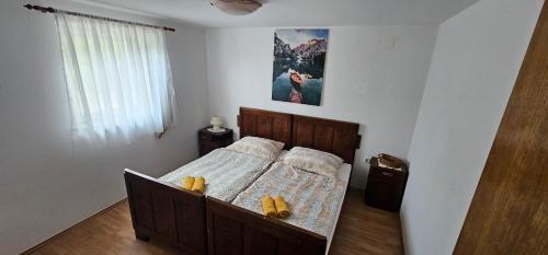 Un dormitorio con una cama con dos zapatos amarillos. en Holiday House Nika, en Vrbovsko