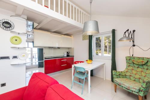 a living room with a red couch and a table at Apartments Montevideo in Mali Lošinj