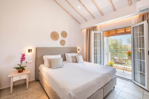 a bedroom with a large bed and a balcony at KORINA APART HOTEL KAVOS in Kavos