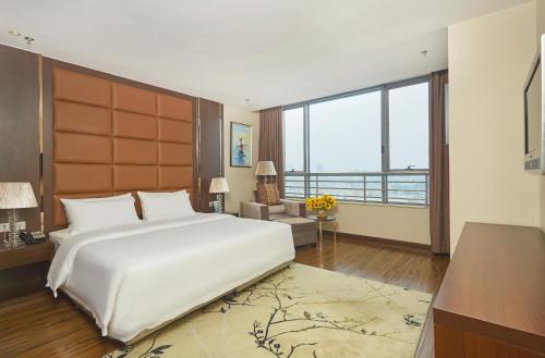 1 dormitorio con 1 cama blanca grande y ventana grande en Beijing Sunflower Hotel en Tongzhou