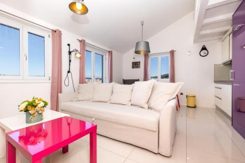 een woonkamer met een witte bank en een tafel bij Apartments Montevideo in Mali Lošinj