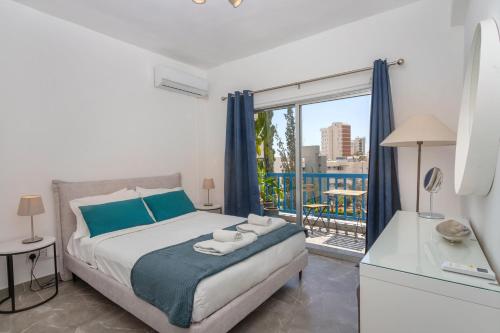 a bedroom with a bed and a balcony at White Arches Apt #2 by TrulyCyprus in Limassol