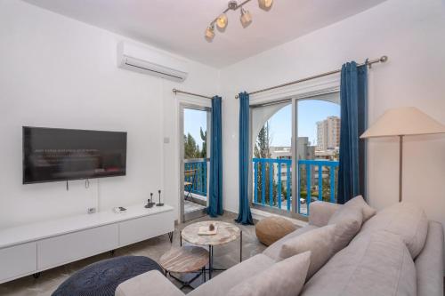 a living room with a couch and a large window at White Arches Apt #2 by TrulyCyprus in Limassol