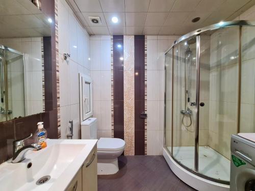 un bagno con doccia, lavandino e WC di Seaview Flag Square Studio Central a Baku