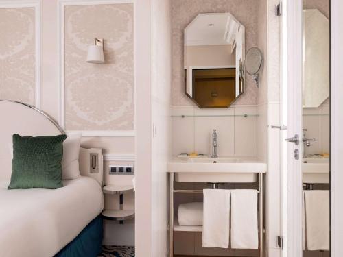 um quarto de hotel com um lavatório e uma casa de banho em Hotel Mercure La Sorbonne Saint-Germain-des-Prés em Paris