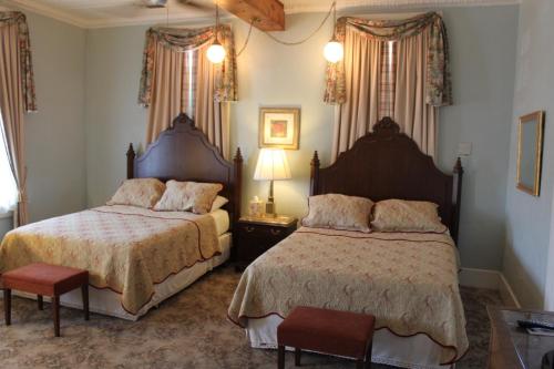 sypialnia z 2 łóżkami, stołem i krzesłami w obiekcie The Hotel Limpia w mieście Fort Davis