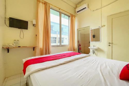 een ziekenhuiskamer met een bed en een raam bij RedDoorz near bandara City Mall in Tangerang