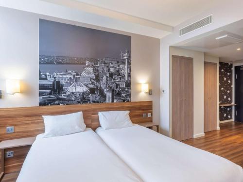 リバプールにあるアパートホテル アダージョ リバプール シティ センターのベッドルーム1室(壁に絵が描かれた白いベッド1台付)