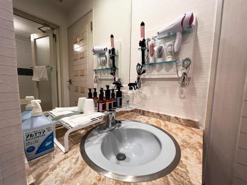 a bathroom with a sink in a room at Hotel HAGOROMO in Hiroshima