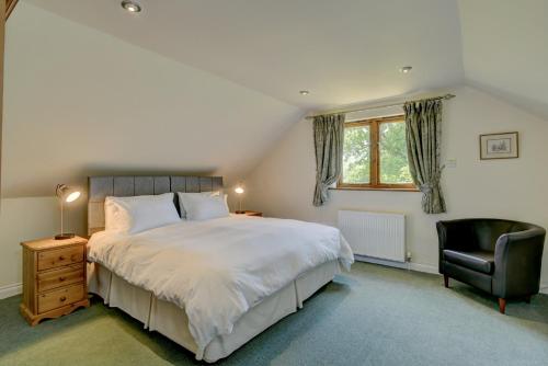 a bedroom with a large bed and a chair at Dunkery View in Minehead