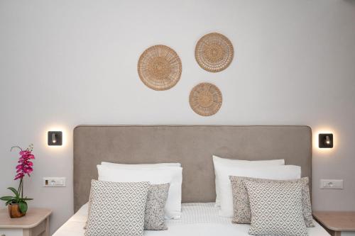 a bedroom with a bed with white pillows at KORINA APART HOTEL KAVOS in Kavos