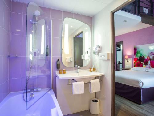 1 cama y baño con lavabo y ducha. en ibis Styles Bourges en Bourges