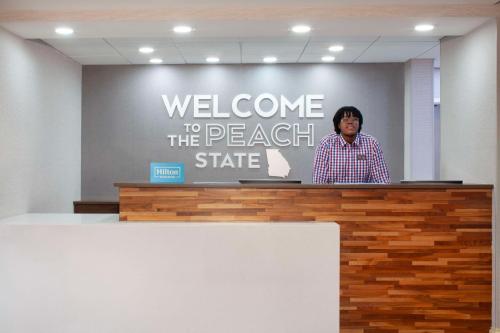 a woman is standing behind a podium at Hampton Inn & Suites-Atlanta Airport North-I-85 in Atlanta