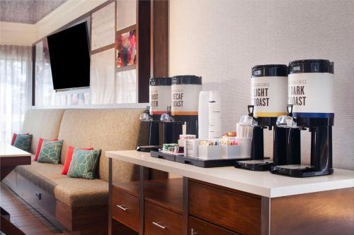 亞特蘭大的住宿－北-I-85亞特蘭大機場-漢普頓套房酒店，一间配备有沙发及带酒瓶的桌子的客房