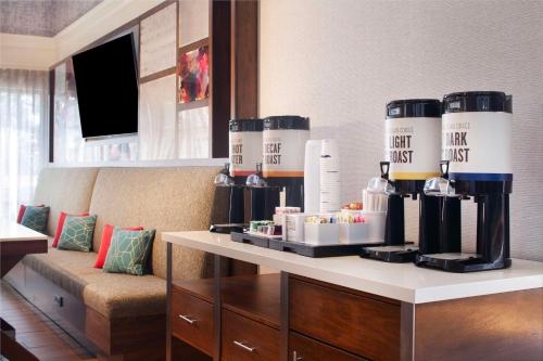 una stanza con un divano e un tavolo con bottiglie di alcolici di Hampton Inn & Suites-Atlanta Airport North-I-85 ad Atlanta