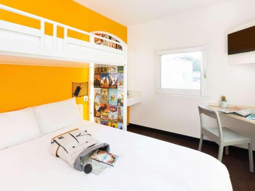 1 dormitorio con cama, escritorio y litera en Hotel F1 Vesoul - En cours de rénovation en Vesoul