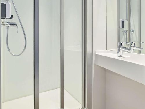 a shower with a glass door next to a sink at Hotel F1 Vesoul - En cours de rénovation in Vesoul