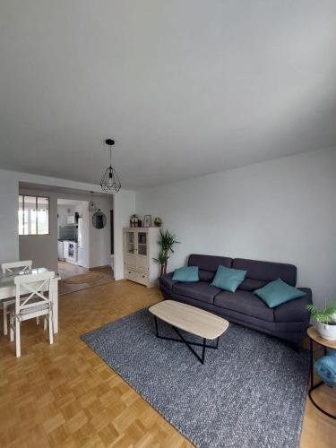 un salon avec un canapé et une table dans l'établissement Appartement spacieux et cosy, à Valence