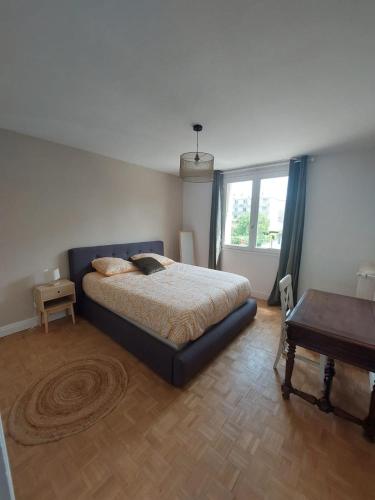 une chambre avec un lit, une table et une fenêtre dans l'établissement Appartement spacieux et cosy, à Valence