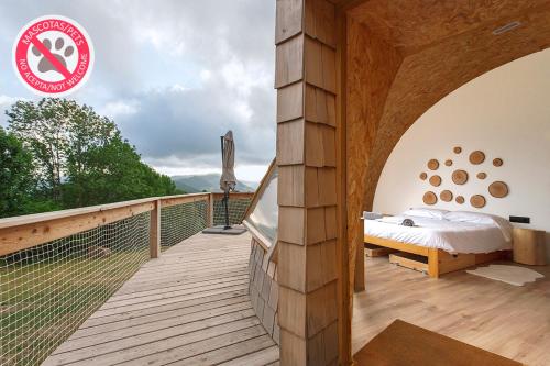 オルバイセタにあるIrati Barneanの木製バルコニーにベッドが備わる客室です。