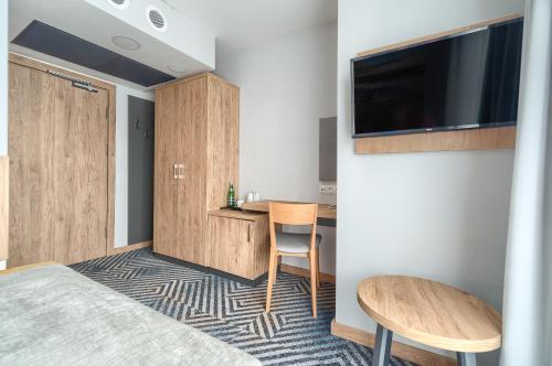 a hotel room with a bed and a desk and a tv at Afrodyta Spa in Świnoujście