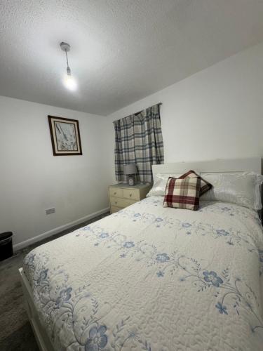 a bedroom with a bed with a plaid pillow on it at Stay at the coaches in Bristol
