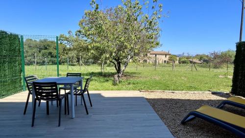 a patio with a table and chairs and a field at Mas Pigem in Pals